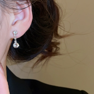 Close-up of silver drop earrings with clear crystals on model showing elegant design