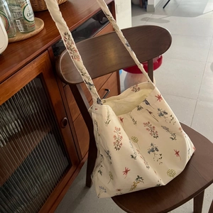 Detailed close-up of a floral canvas tote bag hanging on a vintage wooden chair