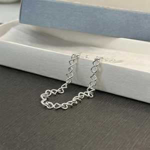 Minimalist 925 sterling silver twisted chain bracelet with lobster clasp on a jewelry box