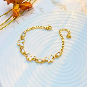 Elegant gold butterfly bracelet with rectangular cubic zirconia on a white ceramic tray