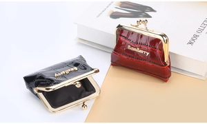 Detail of glossy crocodile pattern coin purses with gold kiss-lock in black and burgundy