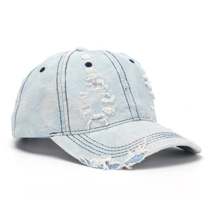 Close-up detail of distressed blue denim baseball cap with vintage frayed ripped effects