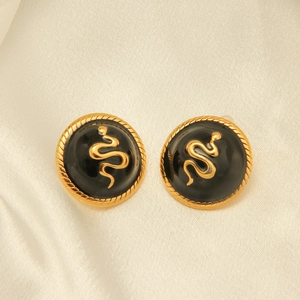 Detailed macro view of retro 18k gold plated snake studs on premium silk texture