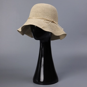 Handmade woven beige straw sun hat for women with wavy brim and stylish bow detail