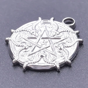 Macro view of silver stainless steel pendant featuring a star and dragon relief design