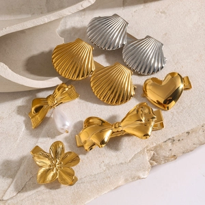 Detailed view of assorted gold and silver metal hair clips with pearls on stone texture