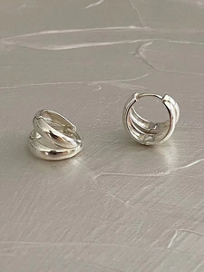 Macro shot of 925 sterling silver geometric hoop earrings with polished finish