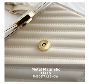 Detailed close-up of golden cylindrical magnetic clasp on beige quilted leather handbag