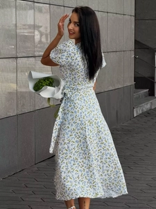 Detail of white cotton floral maxi dress with puff sleeves and waist tie in blue print