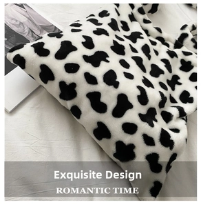 Close-up of soft cow print plush fabric texture on a large capacity shoulder tote bag