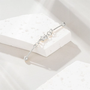 Close-up of S925 silver industrial piercing with zircon flower on white stone