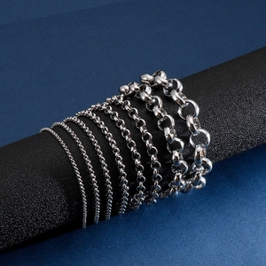 Polished stainless steel chain bracelets for men and women on a black display stand