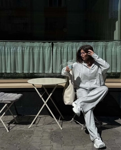 Dettaglio del set felpa grigia con cappuccio e zip con pantaloni a gamba larga in stile street