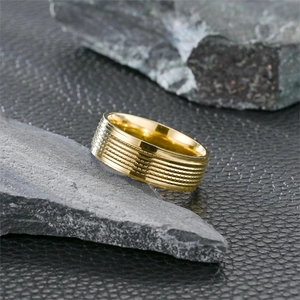 Klassischer goldener Herrenring aus Titanstahl mit horizontaler Rillenstruktur auf Leder