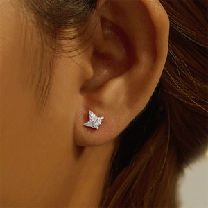 Close-up of silver star cartilage stud earring with center crystal on model's ear