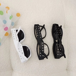 Detailed view of kids' rectangular sunglasses with silver rivets on plush background