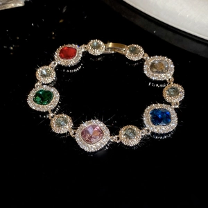 Nahaufnahme eines eleganten Silberarmbands mit bunten Edelsteinen und funkelnden Diamanten