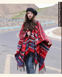 Photo en extérieur d'un poncho ethnique à capuche avec motifs losanges et franges noires