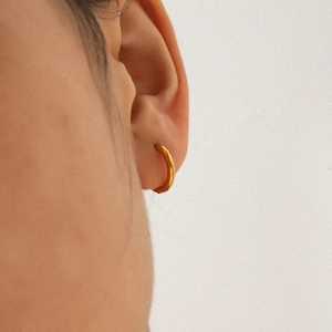 Mini créole en acier inoxydable plaqué or 18k sur l'oreille du mannequin vue de côté