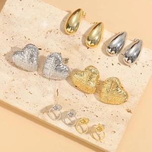 Minimalist heart and drop earring set in gold and silver finish on stone tray