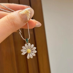 Détail du pendentif fleur de marguerite serti de zircons blancs et pierre jaune centrale