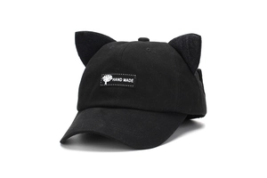 Detail of black cotton cat ear baseball cap with handmade tree woven label on the front