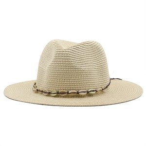 Close-up of straw fedora hat featuring woven texture and white shell beaded band detail