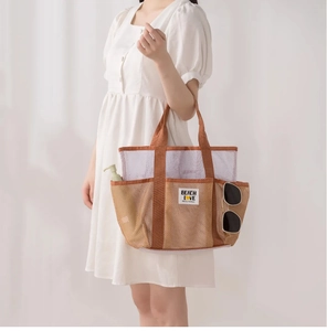 Mesh beach tote detail with 'BEACH LOVE' patch and pockets for travel essentials