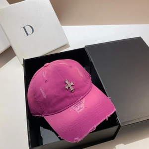 Macro detail of distressed magenta baseball cap with metallic cross emblem in a gift box
