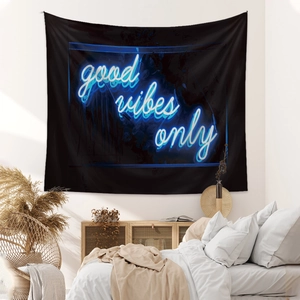 Close-up of a black tapestry with neon blue 'good vibes only' text on a bedroom wall