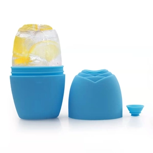 Macro view of blue silicone face ice roller with rose cap and fresh lemon slices