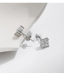 Macro view of flower-shaped moissanite earrings with sterling silver butterfly backings