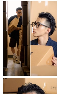 Male model wearing retro large black frame glasses in a warehouse setting showing profile view
