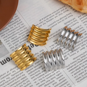 Exaggerated wavy stripe earrings in gold and silver finish with retro metallic texture