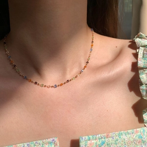 Close-up of a colorful cube crystal necklace with transparent beads and gold chain