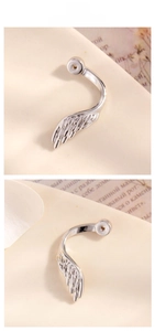 Detail view showing polished silver feather ear cuff with intricate wing texture