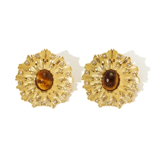 Detailed macro of round vintage sunburst earrings with tiger eye stone and crystals