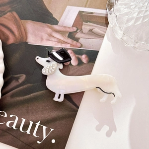 Close-up of a dachshund hair clip with pearl texture and rhinestone hat detail