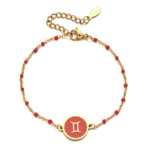 Detail of golden Gemini zodiac bracelet with red enamel charm and stainless steel clasp