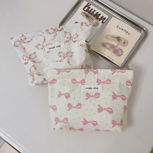 Detail of pink bow and floral fabric cosmetic pouches with simple wish woven labels