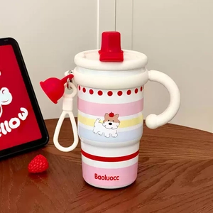 Pink cartoon coffee tumbler with ceramic lining and silicone handle on wooden desk