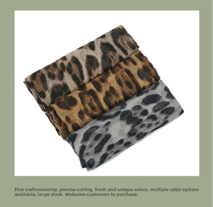 Close-up of leopard print scarves in brown, tan and grey with fringe edges