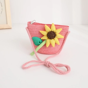 Detailed view of pink woven straw crossbody bag with bright yellow sunflower decoration