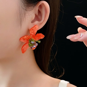 Close-up of vintage orange flower earrings with colorful crystal beads on a model