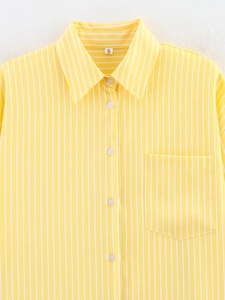 Detail of yellow and white striped shirt fabric with collar and button-up closure