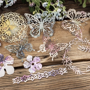 Vintage scrapbooking paper set with hollow butterfly and floral designs on wood