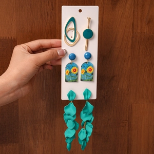 Detail view of a 3-pair earring set featuring Van Gogh's sunflowers and teal petal tassels