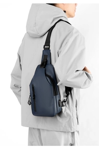 Detailed view of blue waterproof chest bag with USB port on a male model for outdoor use