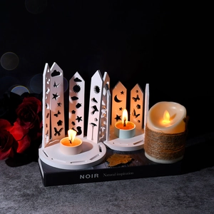 Detail of white hollowed-out star and moon patterns on decorative candle holder