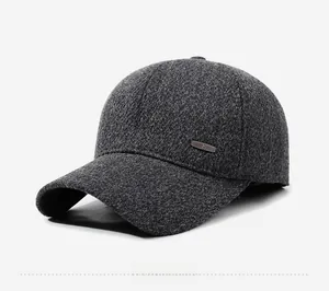 Detail view of dark grey wool baseball cap showing premium texture and metal emblem